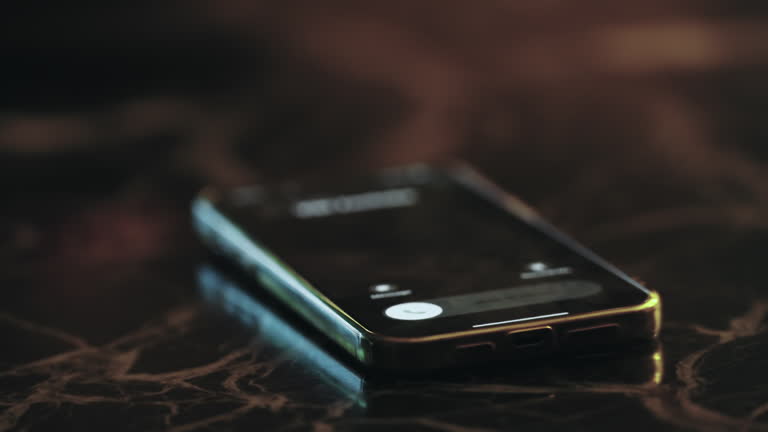 Mobile phone lying on a dark table as an incoming call times out